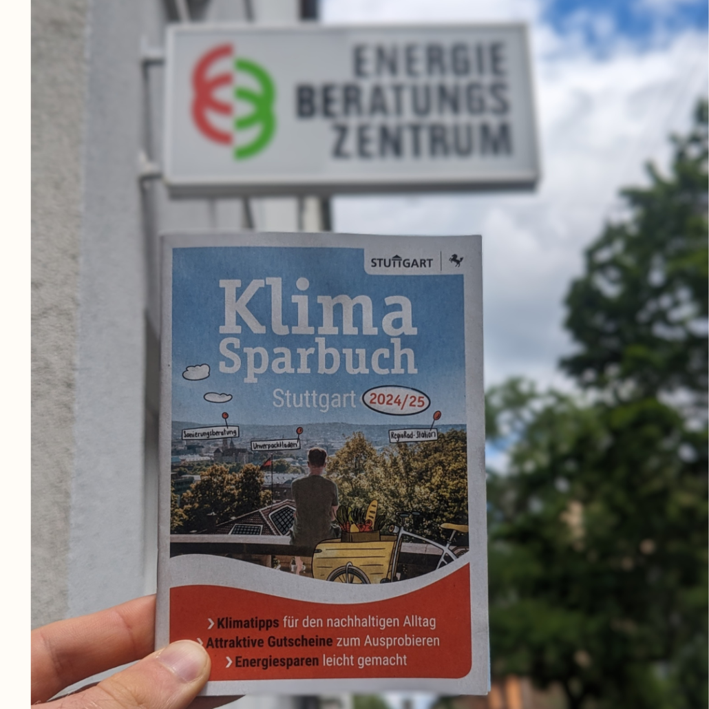 Vor dem Firmenlogo auf dem Gebäude des EBZs hält eine Hand das Klima Sparbuch