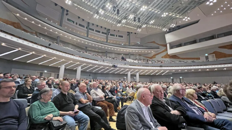 Im Saal der Liederhalle Stuttgart sitzen viele Menschen und blicken zur Bühne.