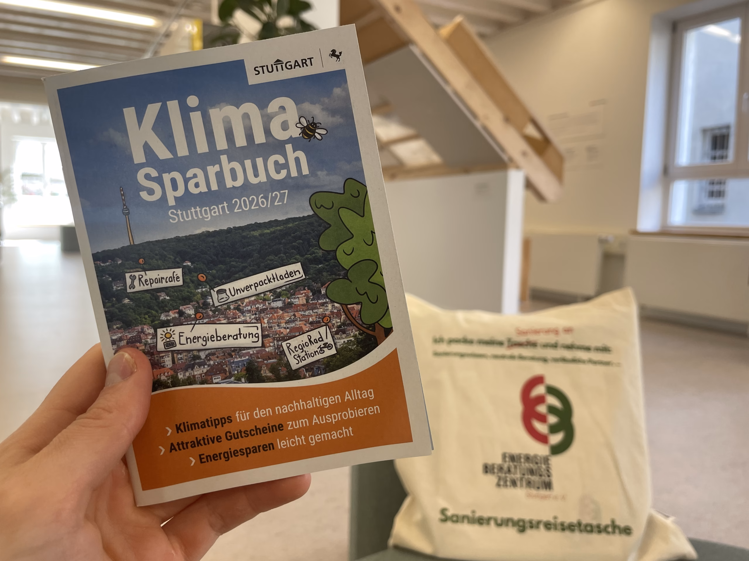Das Klimasparbuch vor der Ausstellung des EBZ und der Sanierungsreisetasche