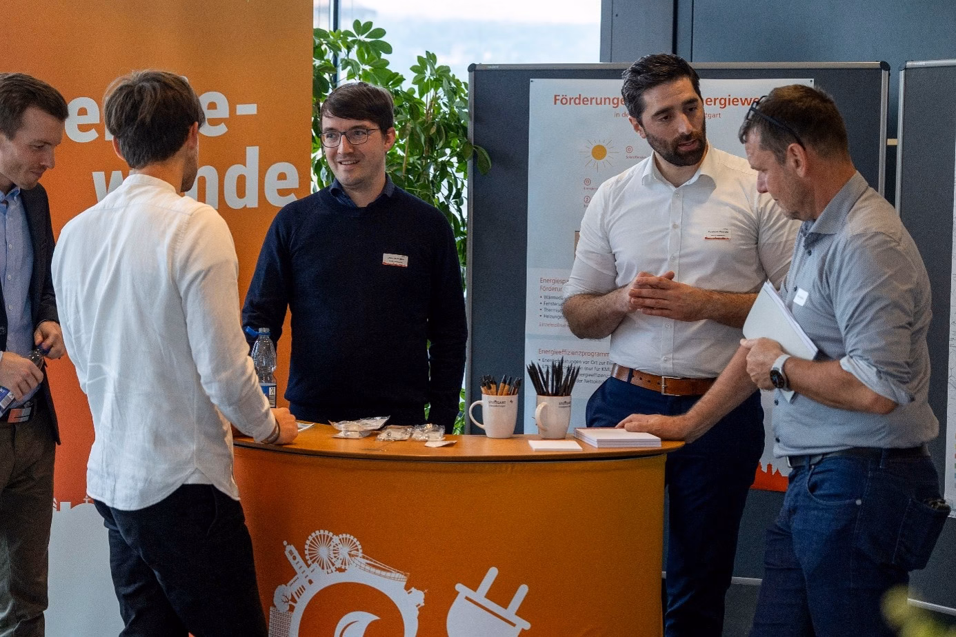 Menschen unterhalten sich an einem Messestand über die Stuttgarter Energiewende